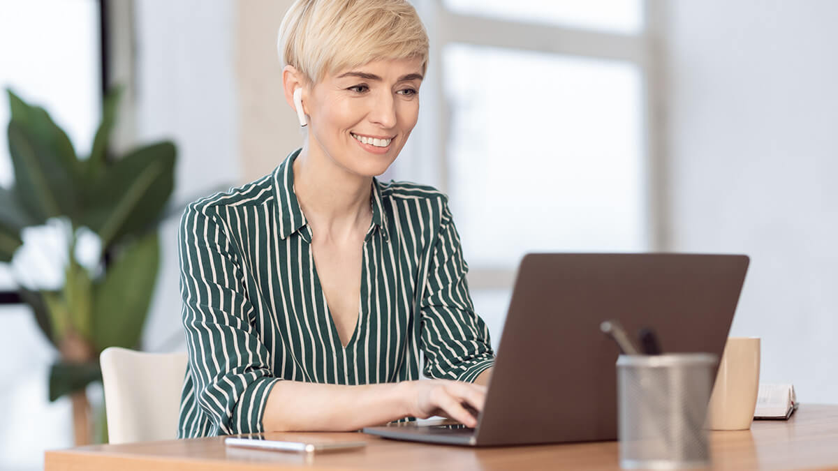 Smiling woman using a laptop.