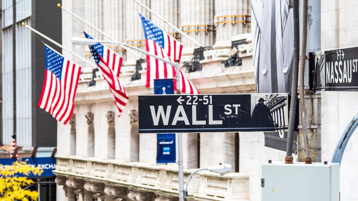 building on wall street with line of flags