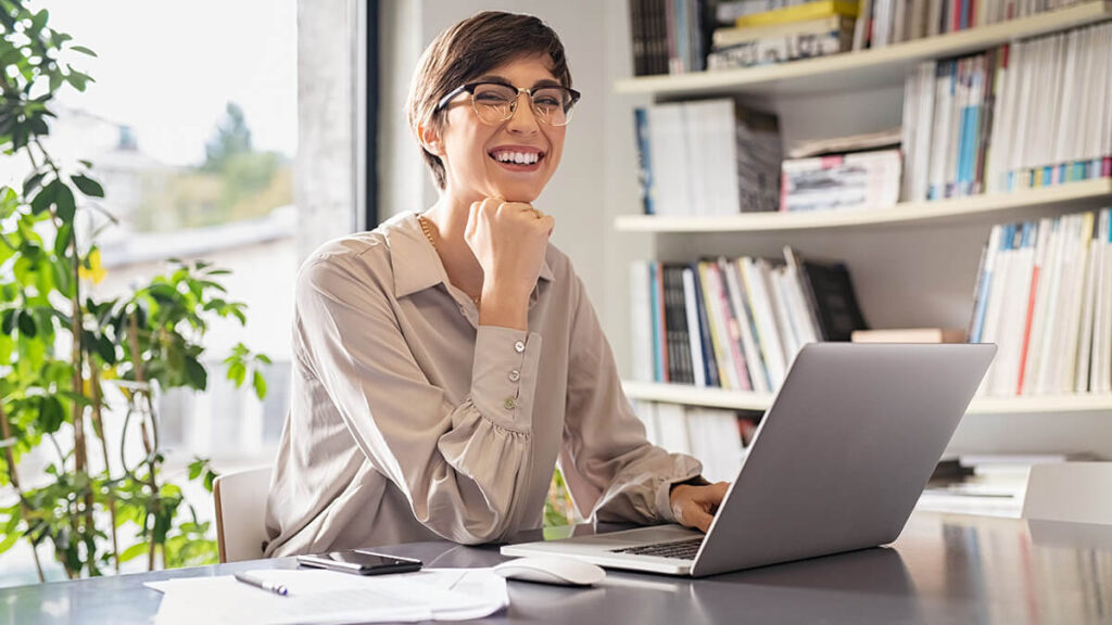 Smiling woman using a laptop.