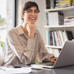 Smiling woman using a laptop.