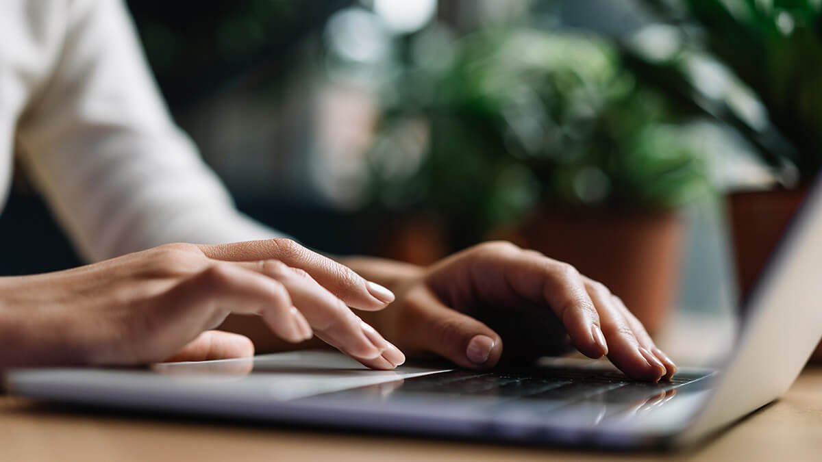 Woman running paperless payroll on laptop.
