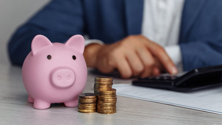 Pink piggy bank and a pile of coins.