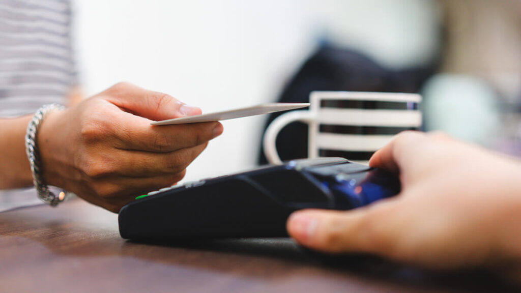 Customer tapping her credit card on a payment processing system.