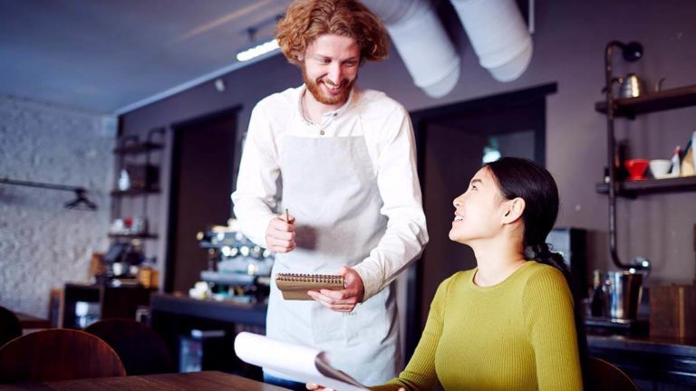 Male waiter taking a customer's order.