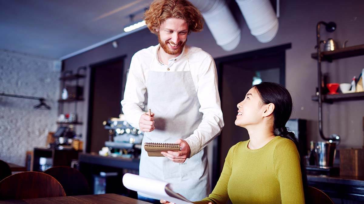 Male waiter taking a customer's order.