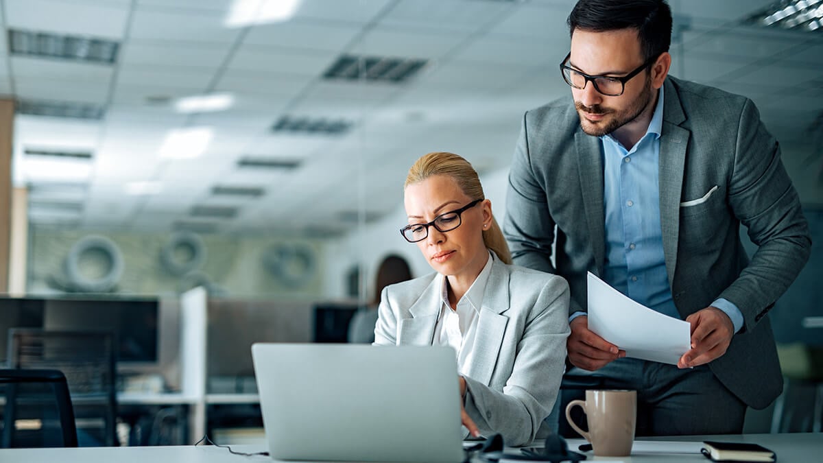 Two business professionals reviewing fixed costs.
