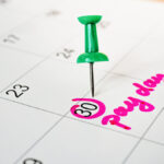 Pay day marked with a pin on a calendar.