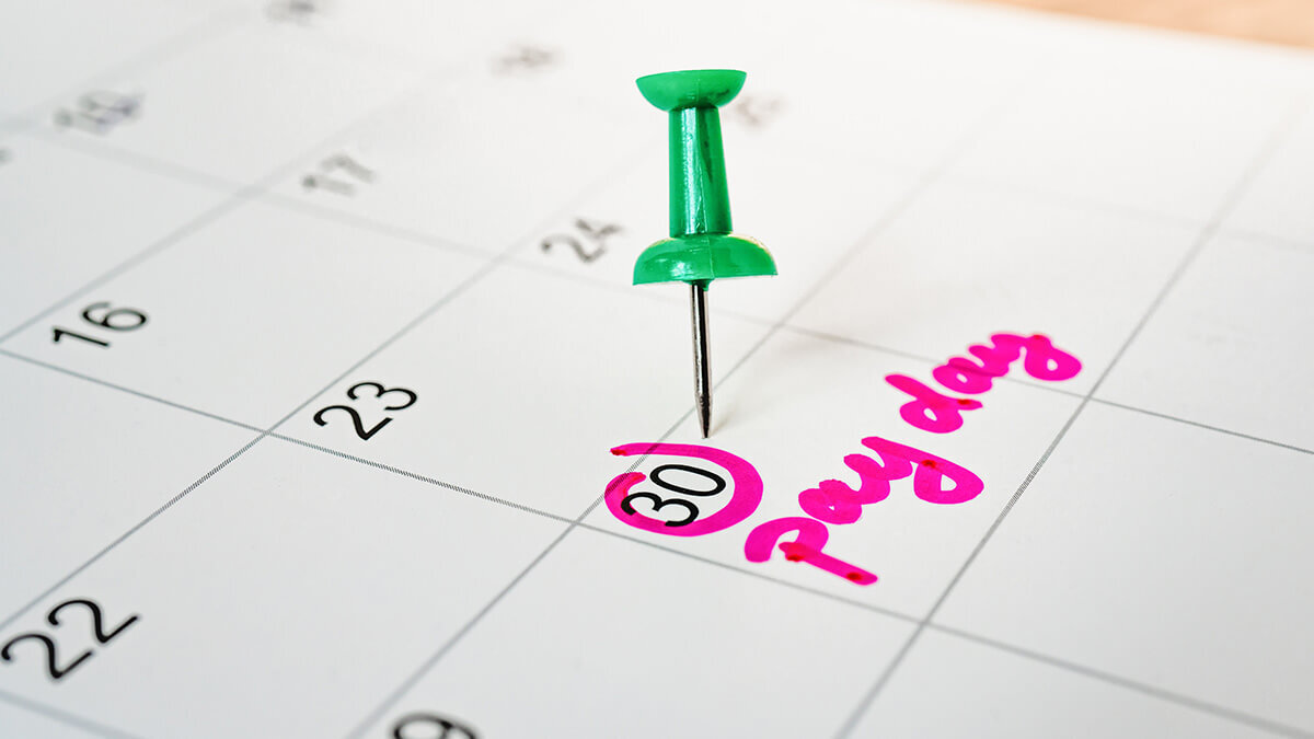 Pay day marked with a pin on a calendar.