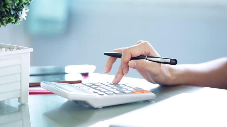 Business owner using white calculator.