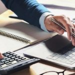 Business owner running payroll on laptop.