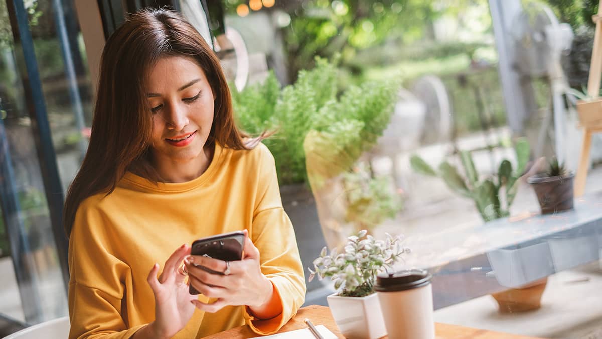 Woman looking at the benefits of direct deposit on her phone.
