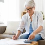 woman filling out tax forms at home