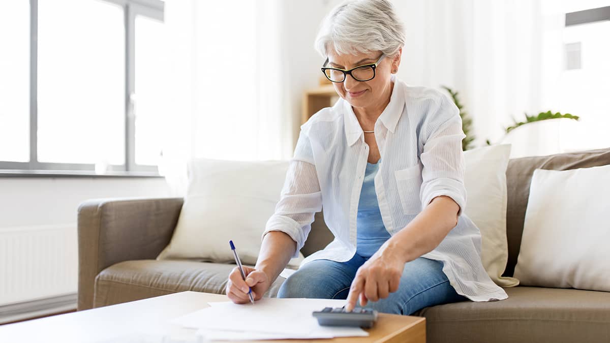 woman filling out tax forms at home