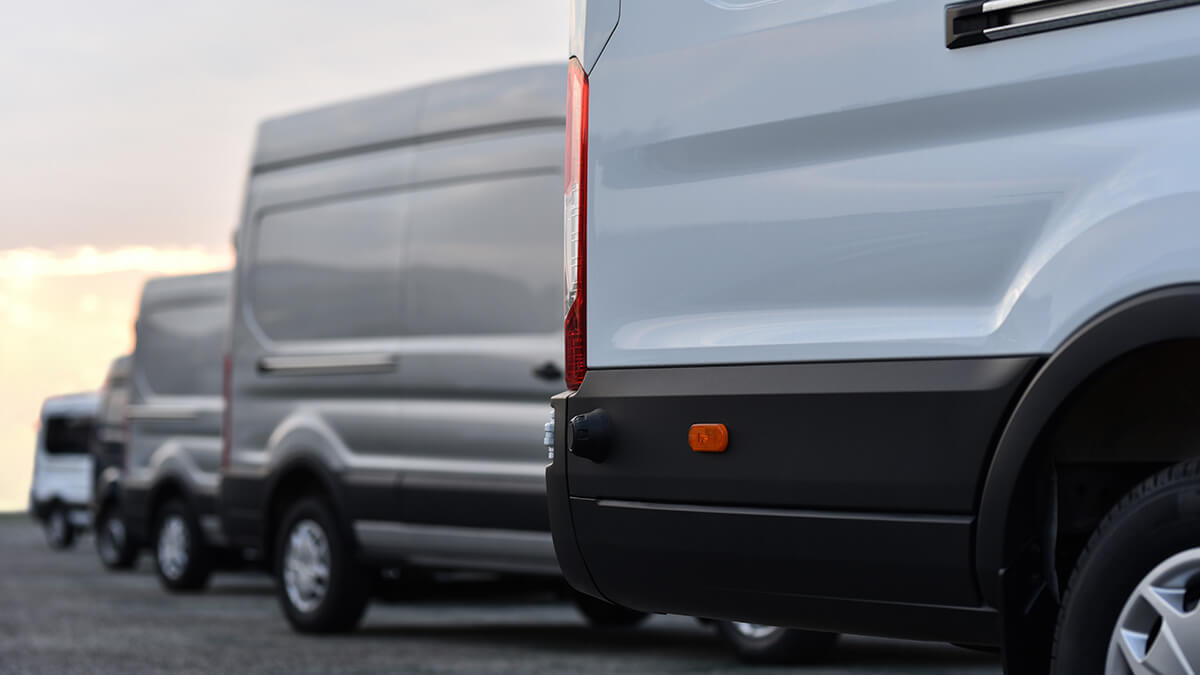 Fleet of work vans in a parking lot.