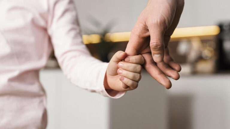 Child holding parent's hand.