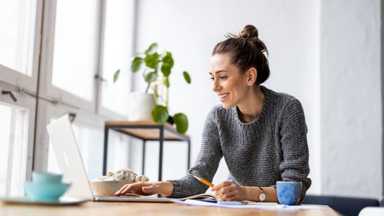 Smiling woman using a laptop.