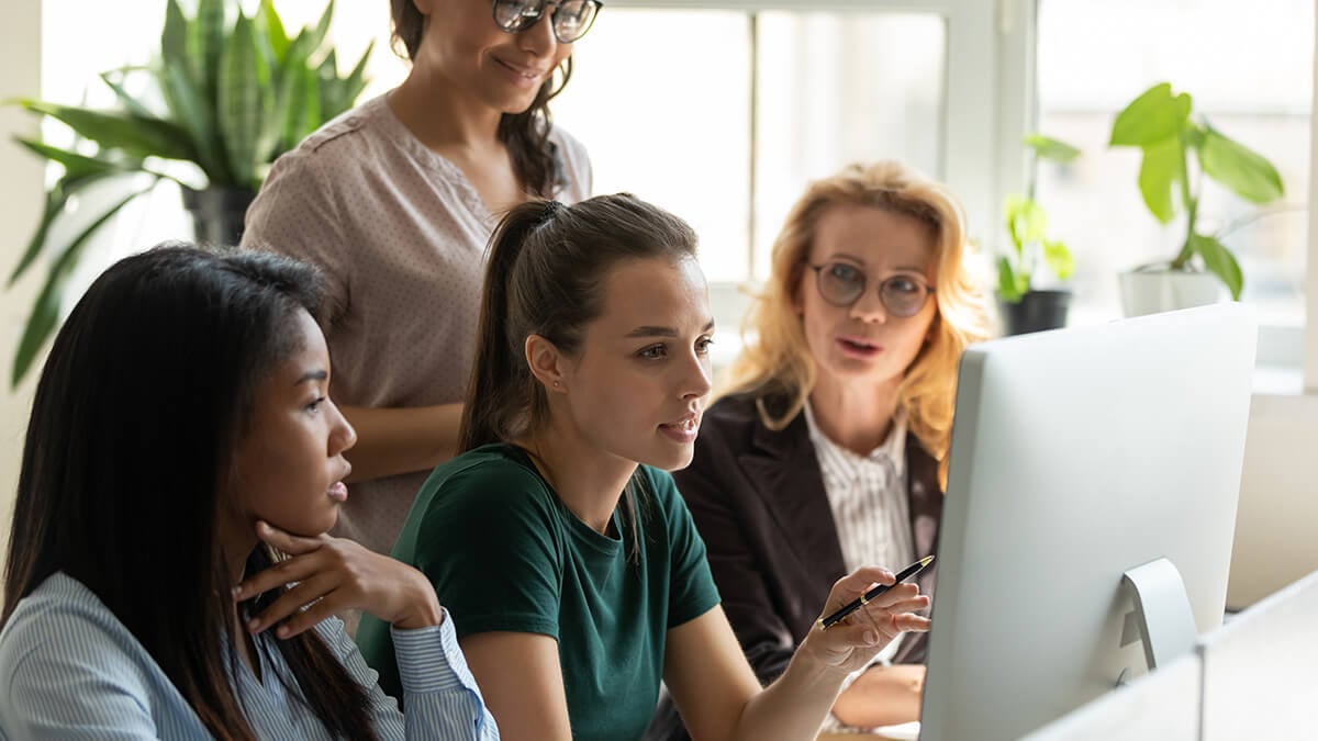 Four women looking at a computer.