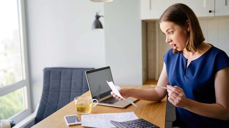 Surprised woman looking at company's sales projections.