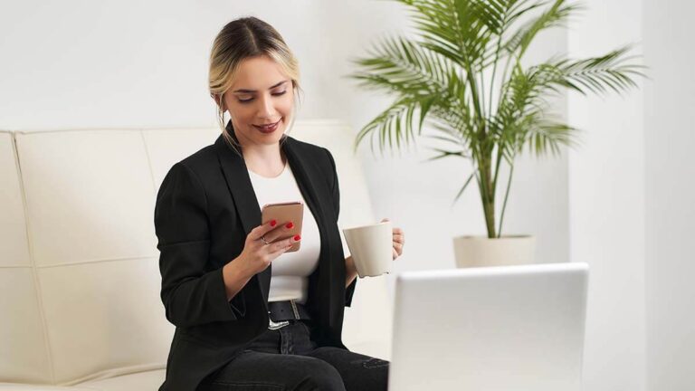 Woman holding a mug and researching how much it costs to start a business.