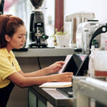 Barista in apron reviewing a receipt.