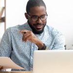 Man posting journal entries to the general ledger online.