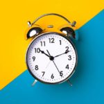 clock ticking with a bright yellow and blue background