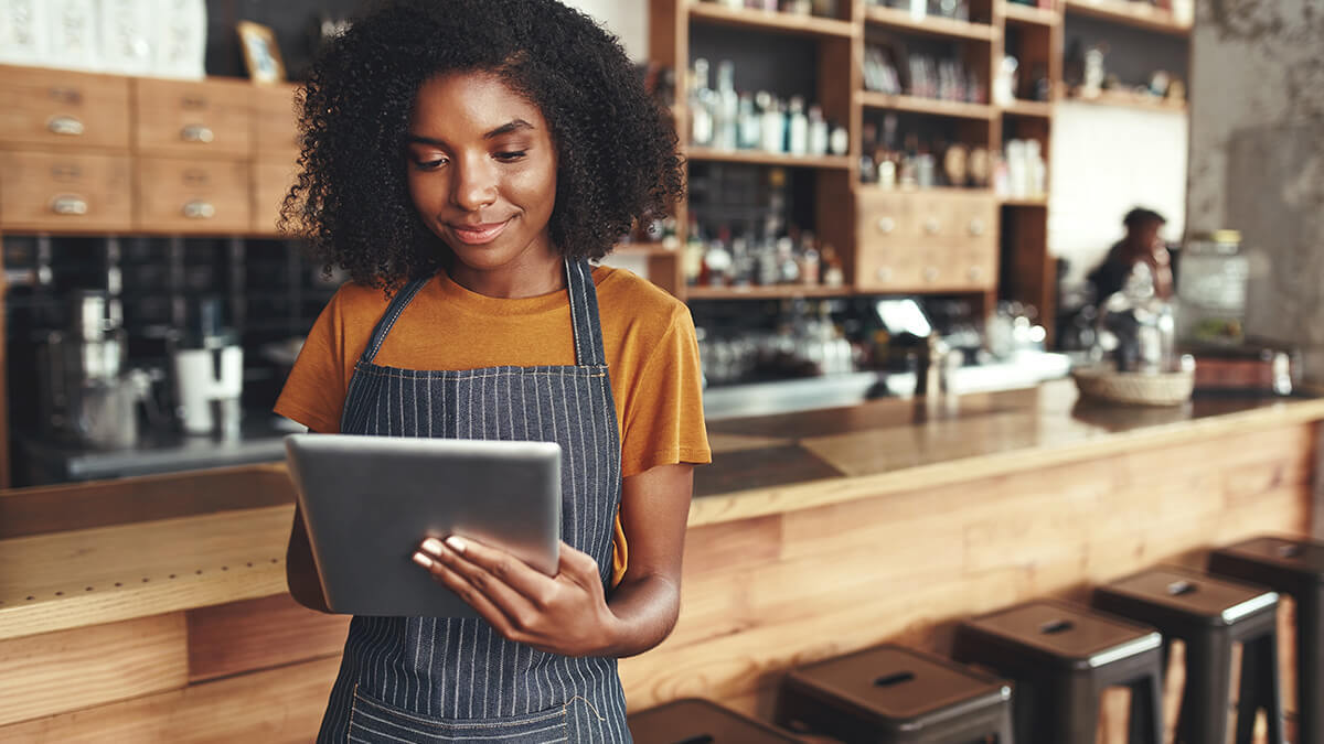 Barista looking at tablet.