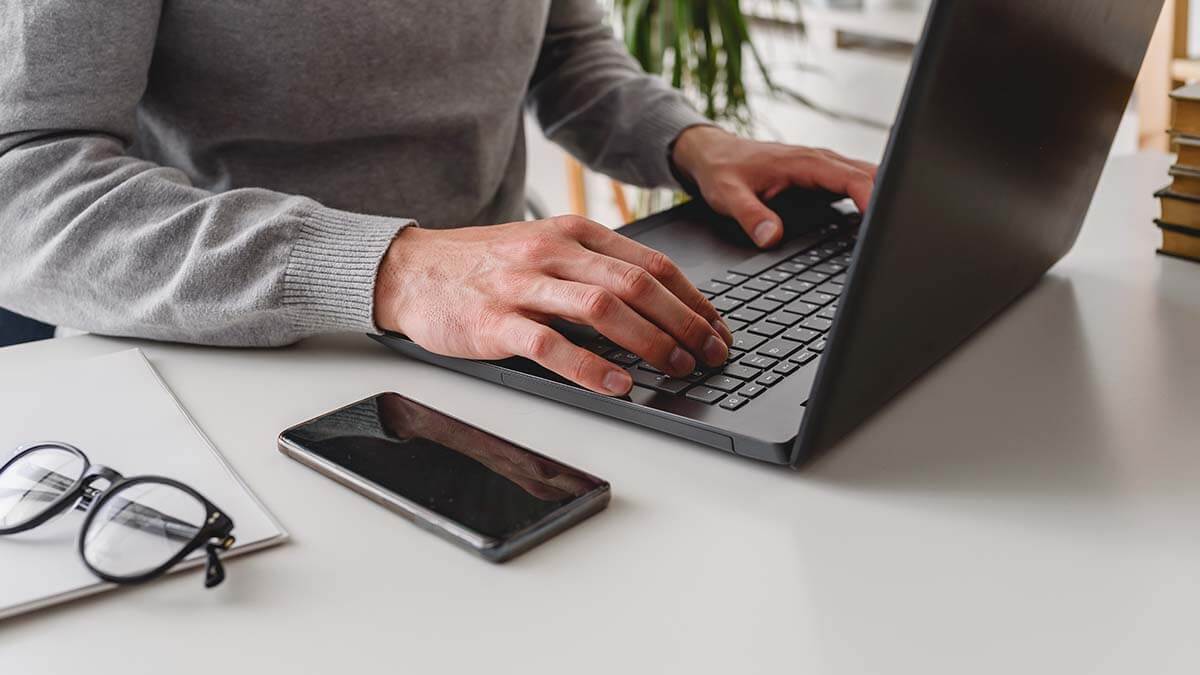 Man calculating cost of living adjustment on laptop.