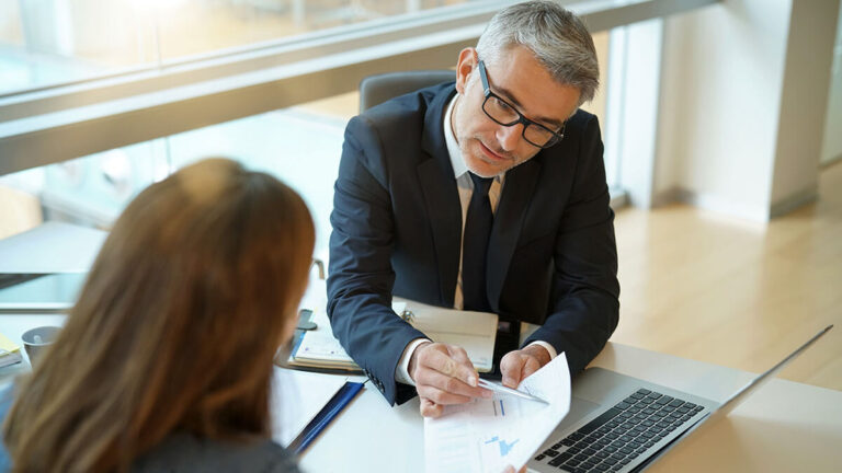 Banker reviewing financial statements with business owner.