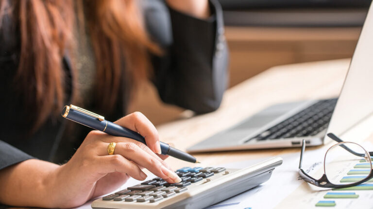 Business owner calculating severance pay on calculator.