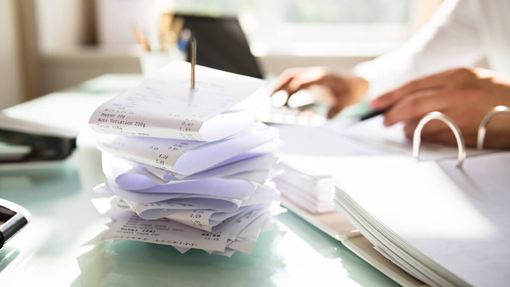 Stack of receipts on a business desk.