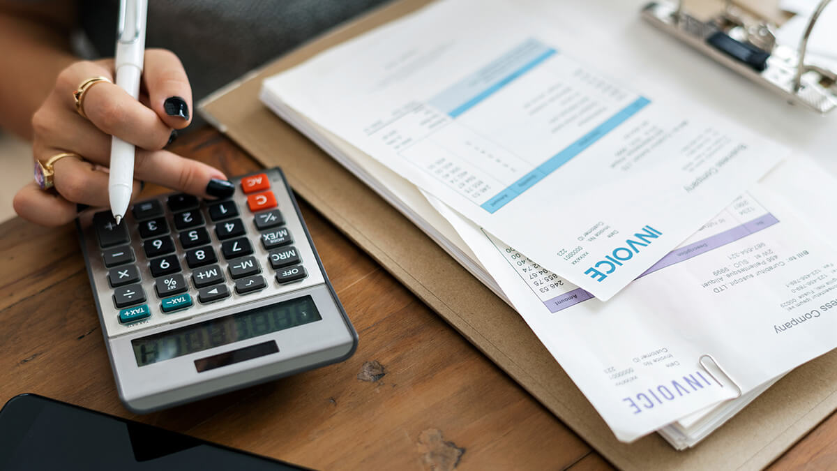Business owner calculating invoice factoring.