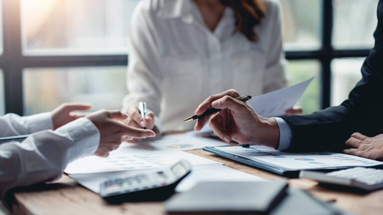 Three professionals handling profit and loss management.