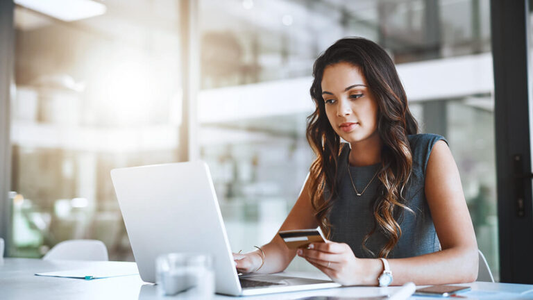 Employee entering credit card information on computer.