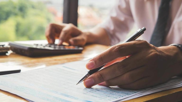 Employer doing a tax gross-up for payroll with a calculator.