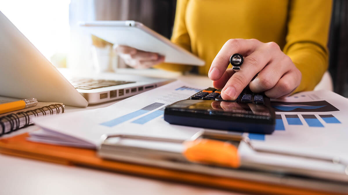 Woman using a calculator and accounting for intangible accounts.