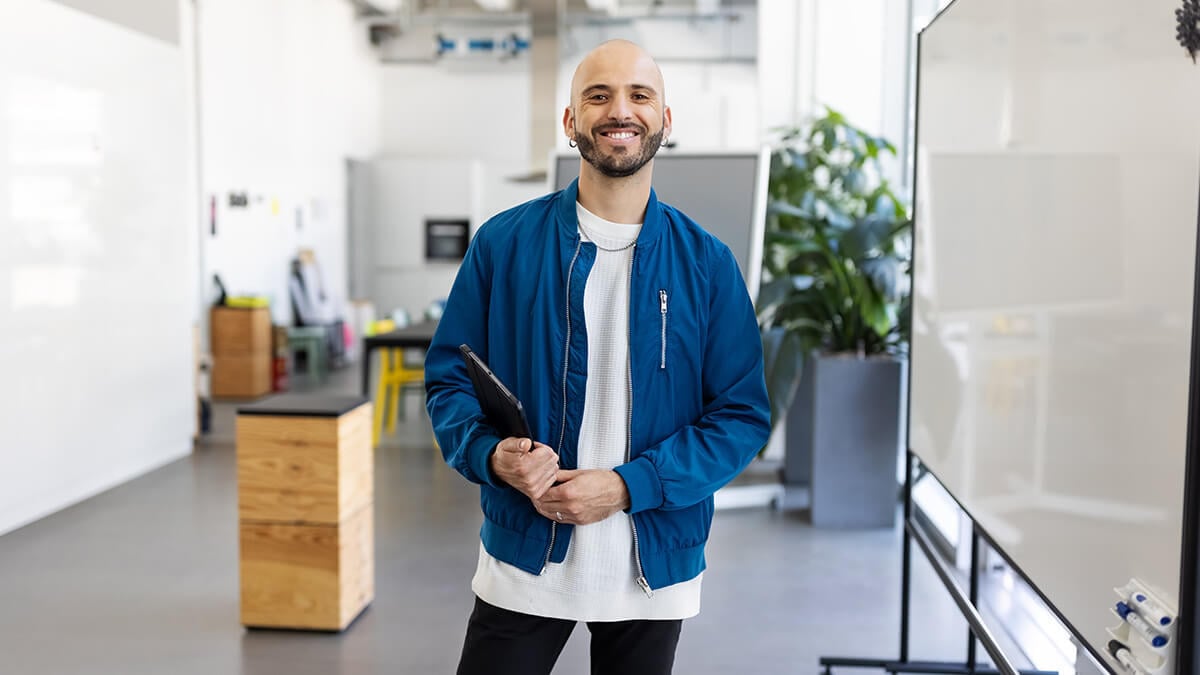 Male business owner smiling at the camera.