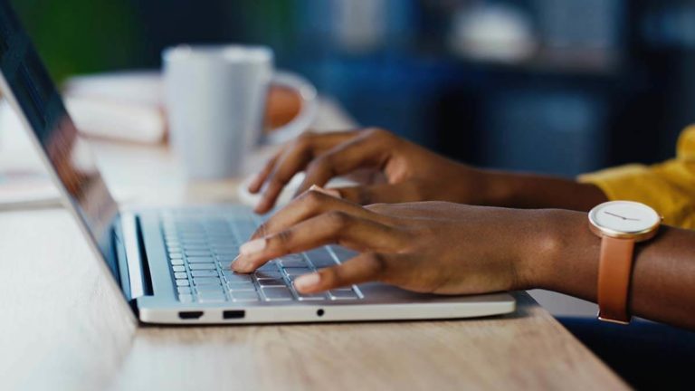 Woman's hands on a laptop keyboard.