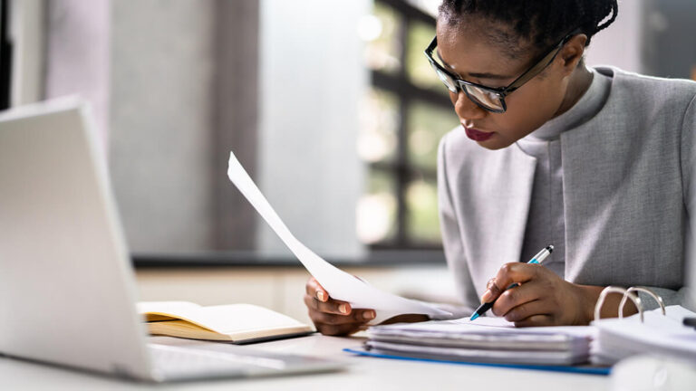 Woman wrapping up her books with closing entries.