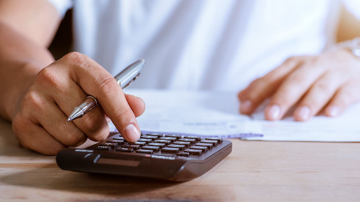 Employer calculating wage garnishment on calculator.