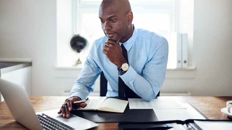 Man in a suit using a laptop.