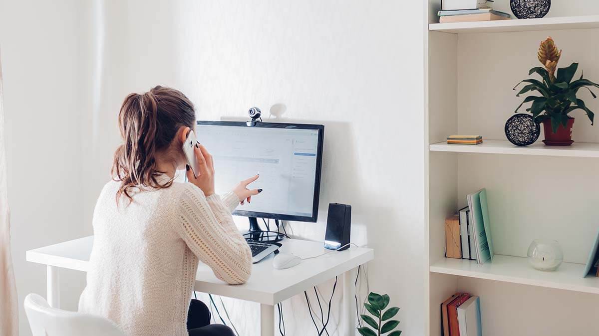 Woman pointing at her desktop computer.