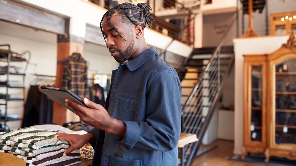 Retail store owner looking at a tablet.