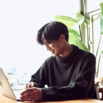 Man smiling at his laptop.