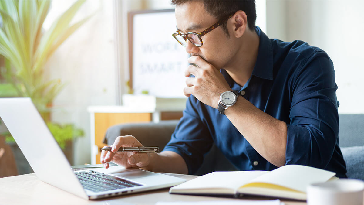 Man working at a laptop on a desk.
