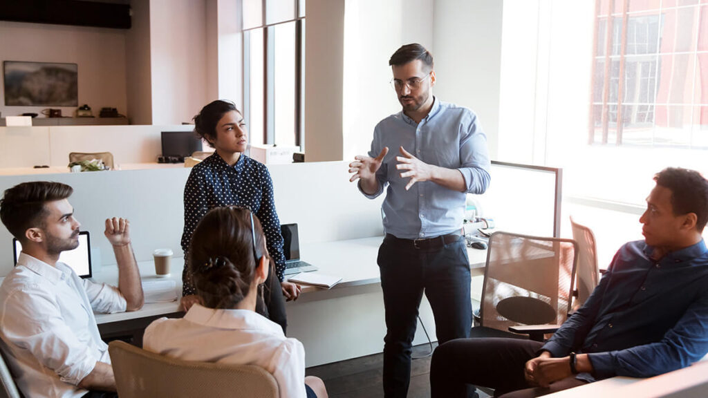 Team of employees talking in a circle.