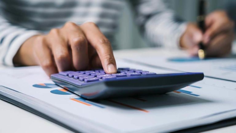 Person entering numbers into a calculator.