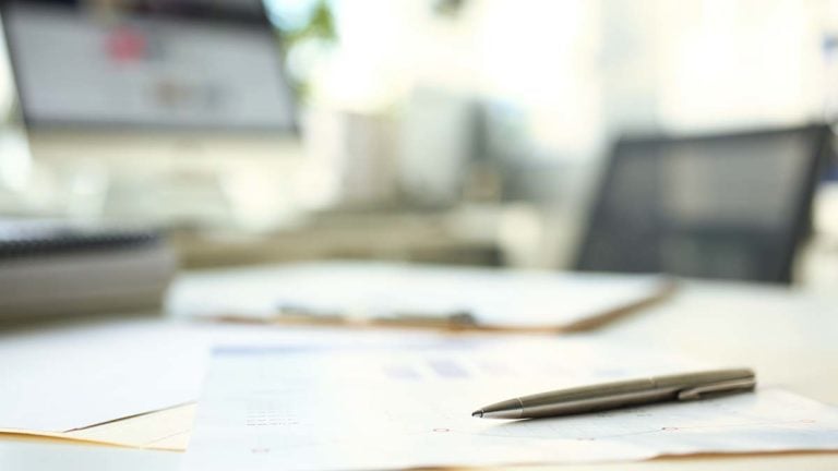 Pen and paper on a desk.