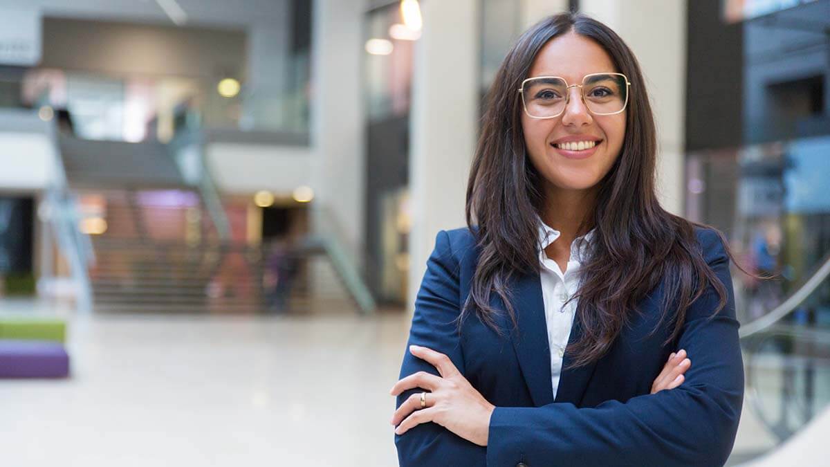 Woman wearing glasses smiling at the camera.