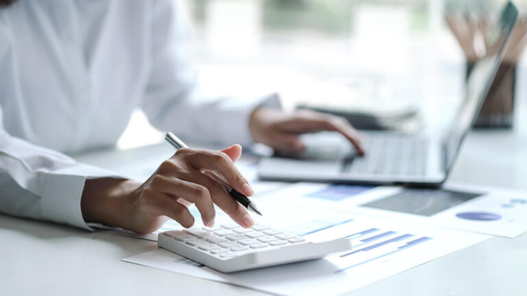 Person using a white calculator.